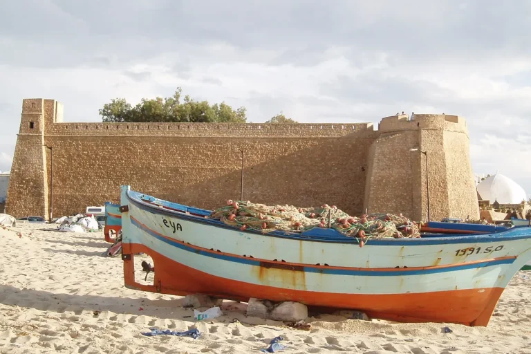 kasbah de Hammamet vue depuis la plage, barque de pêche au premier plan