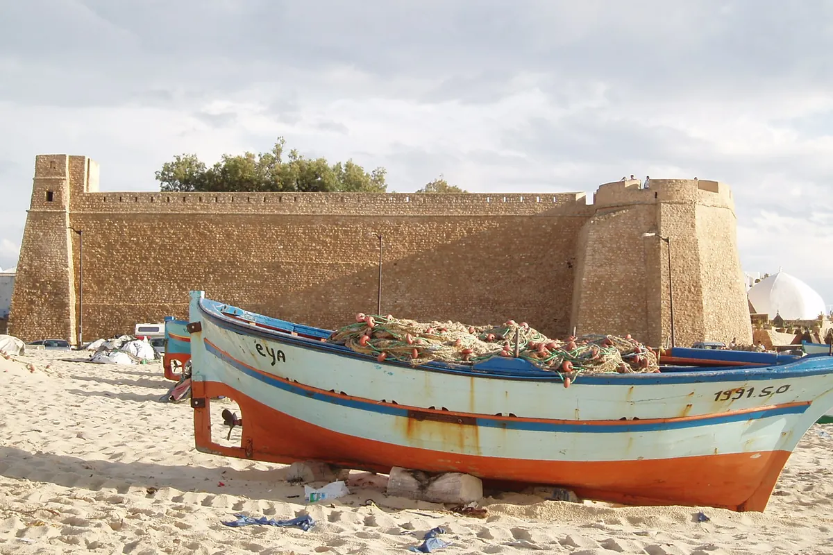 kasbah de Hammamet vue depuis la plage, barque de pêche au premier plan